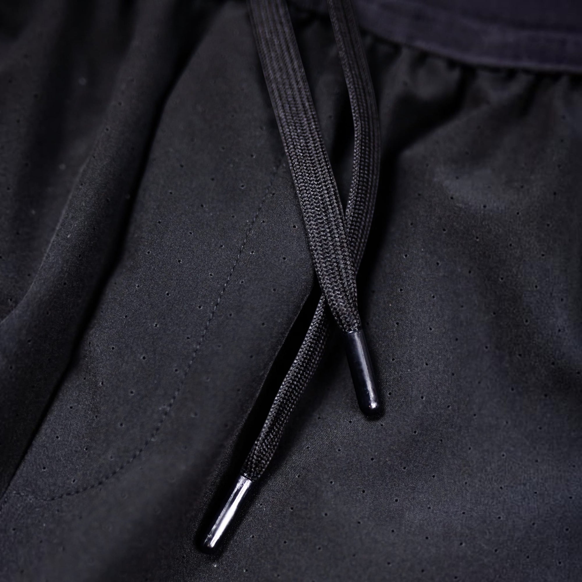 Close-up of black MOVE sport apparel Agility training shorts featuring perforated fabric and a drawstring waist.