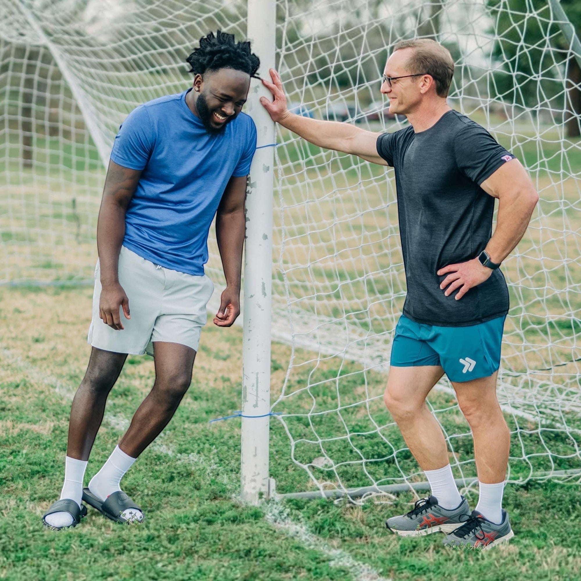 MOVE sport apparel Agility 6 inch training shorts in teal worn by a man standing next to a soccer goal