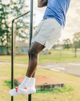 MOVE sport apparel Agility 6 inch training shorts in light grey worn by an athlete performing pull-ups outdoors