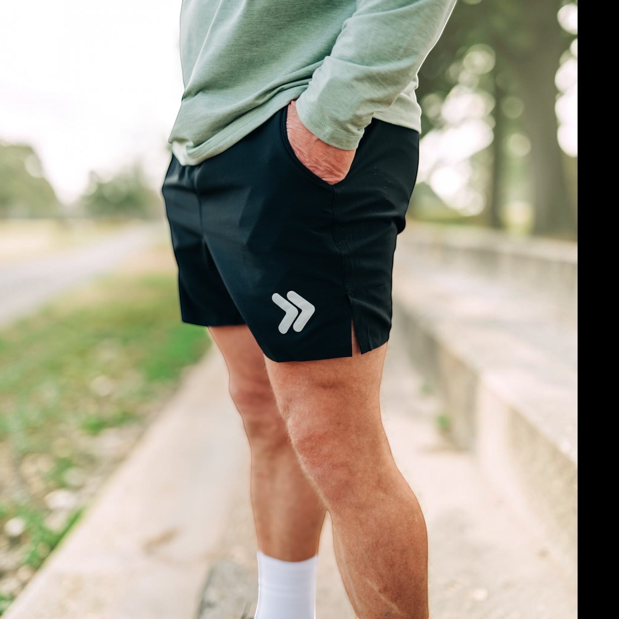 MOVE sport apparel Agility 6 inch black training shorts with white logo detail worn by a man outdoors