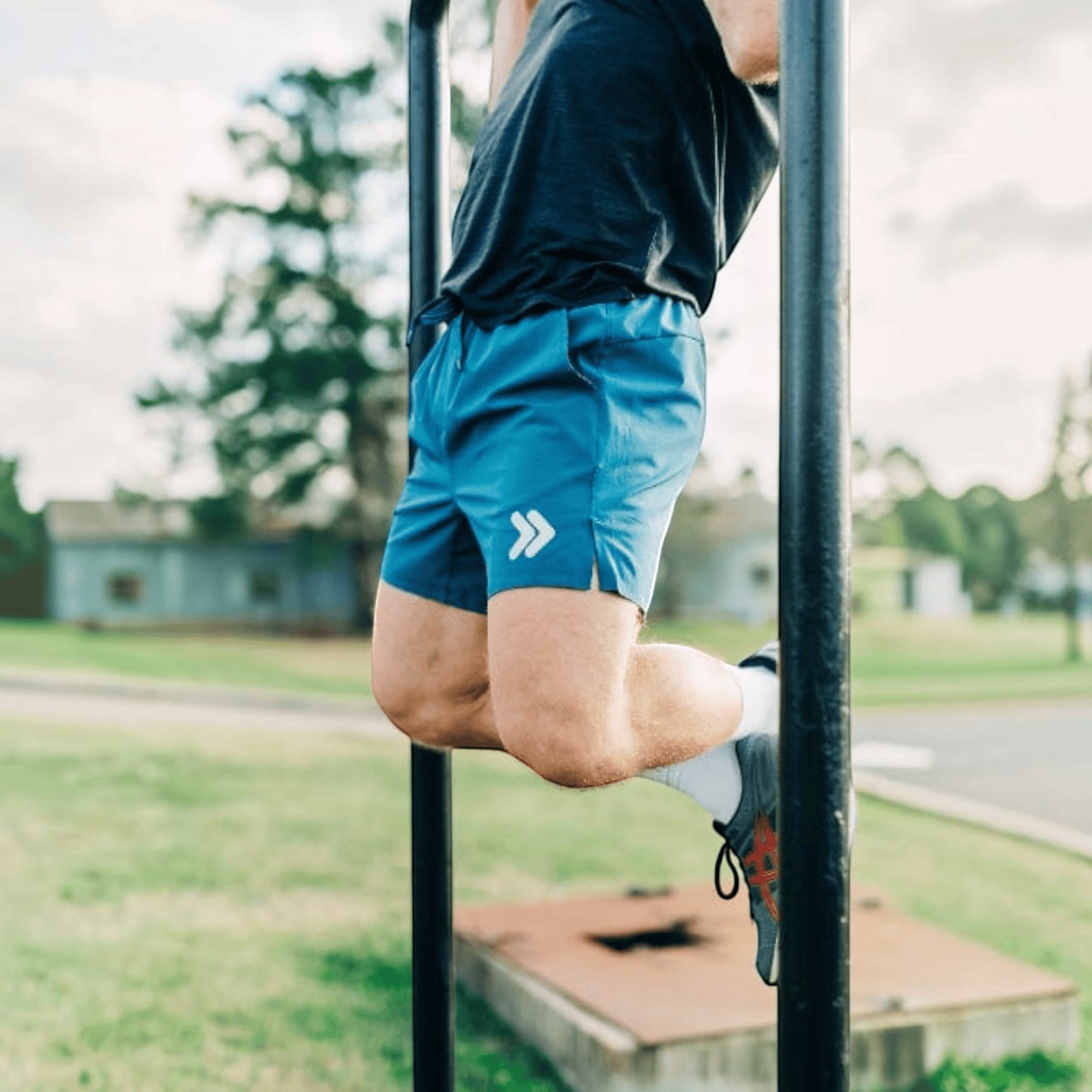 MOVE sport apparel blue 6 inch agility training shorts with boxer brief liner worn by a man doing pull-ups outdoors