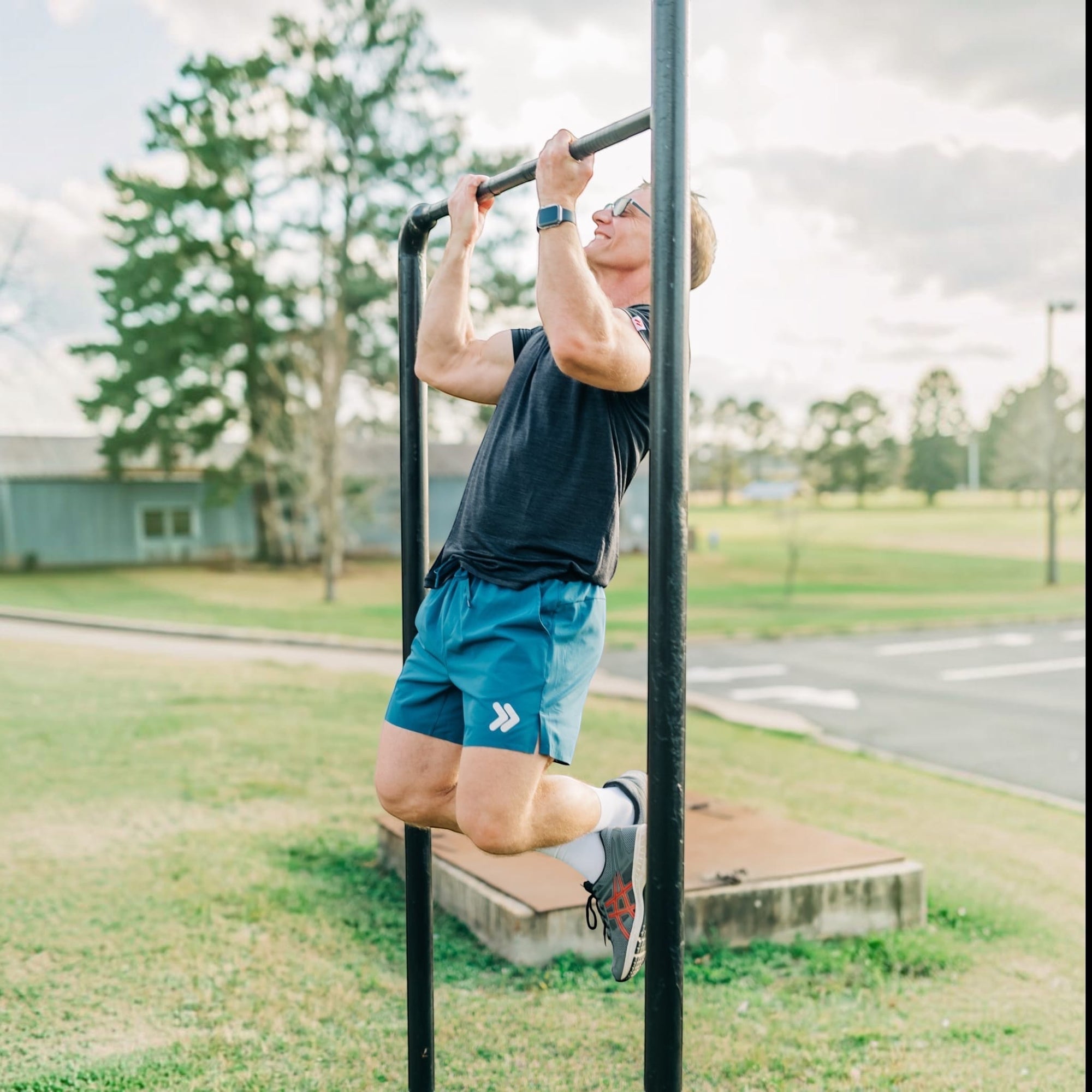 MOVE sport apparel Agility 6 inch training shorts in blue worn by a man doing pull-ups on an outdoor bar