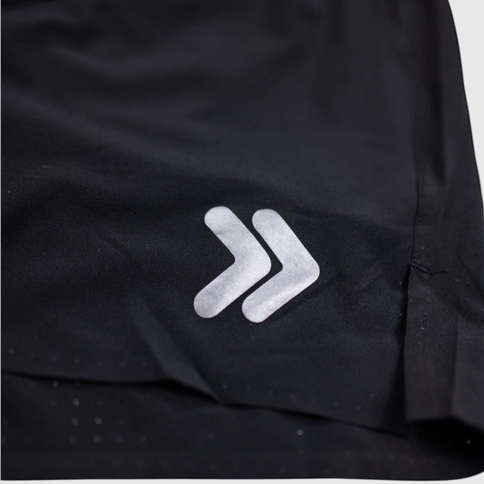 MOVE sport apparel black Agility training shorts featuring a reflective logo detail and perforated fabric texture
