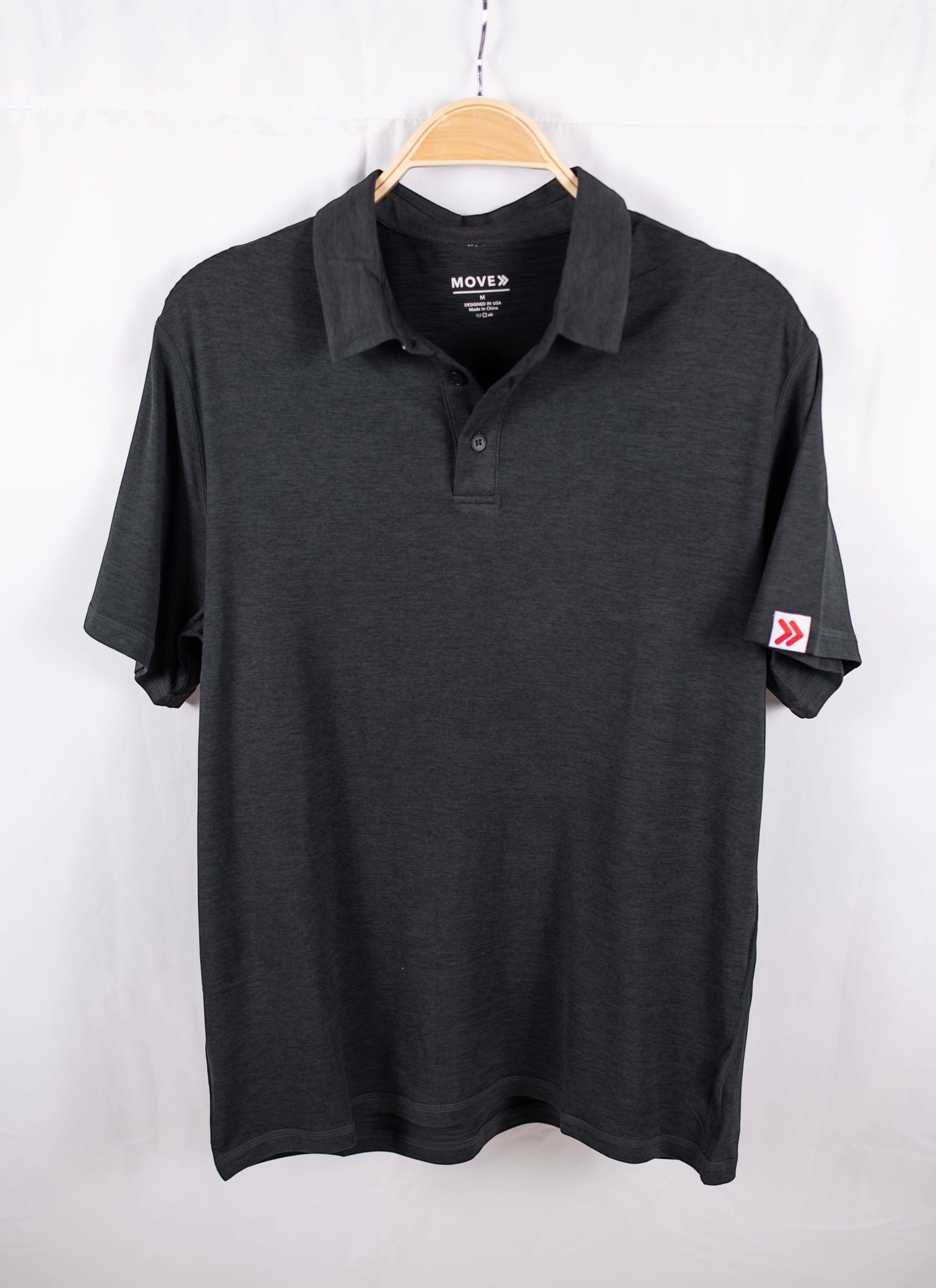 MOVE sport apparel Essential Polo Shirt in charcoal grey moisture-wicking fabric with a classic collar and logo patch