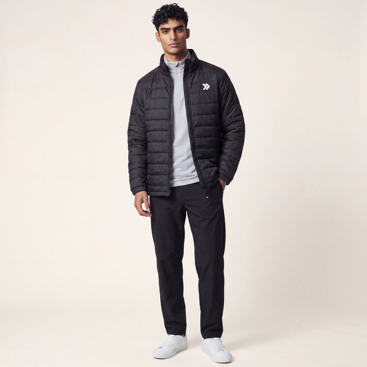 A model wearing a MOVE sport apparel black lightweight quilted down jacket with a stand-up collar and logo patch.