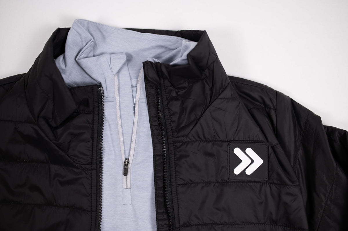 MOVE sport apparel black lightweight quilted down jacket with stand-up collar and logo patch over a light blue zip top