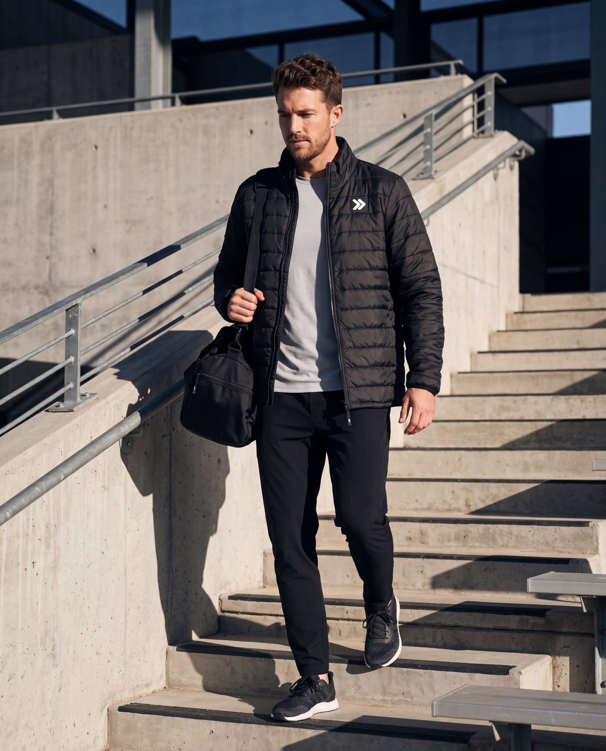 MOVE sport apparel men's black lightweight quilted down jacket with stand-up collar worn by a man on concrete stairs