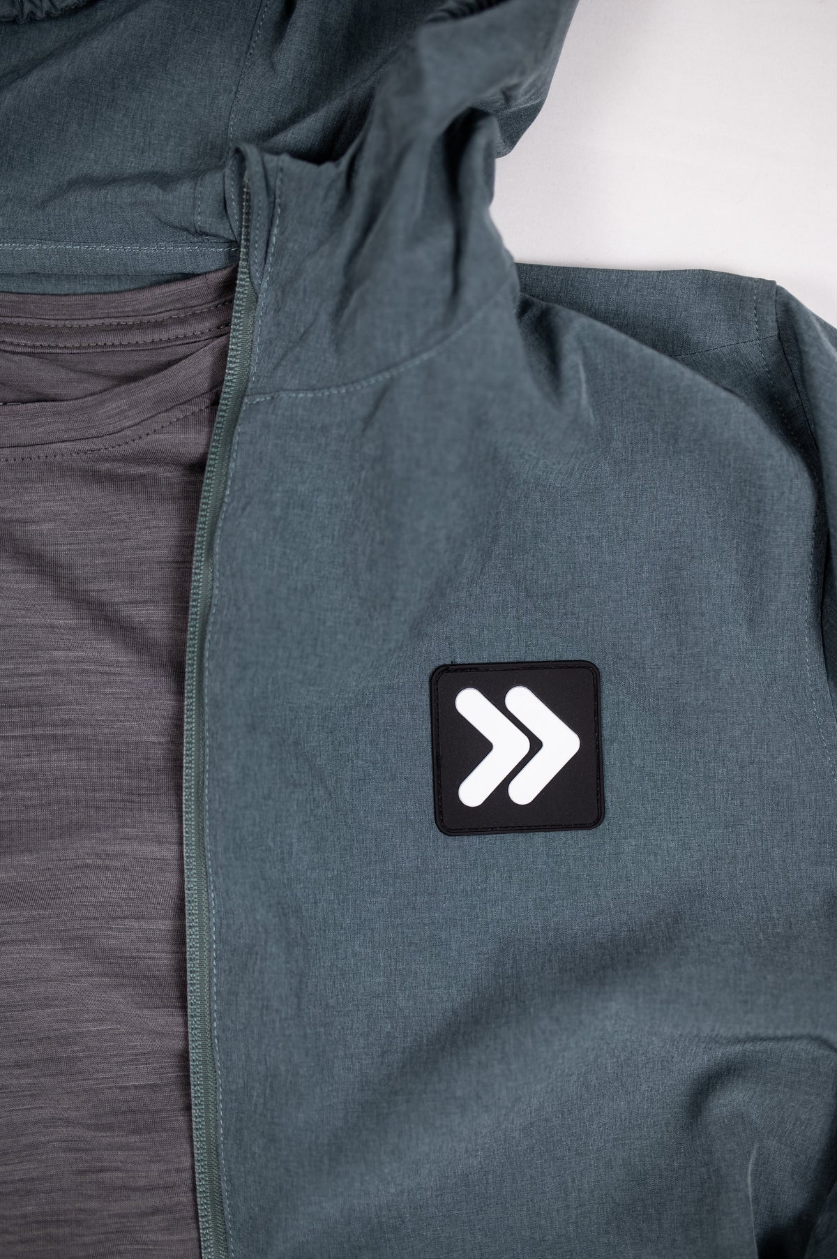 MOVE sport apparel grey hooded jacket with logo patch layered over a charcoal merino wool long sleeve shirt