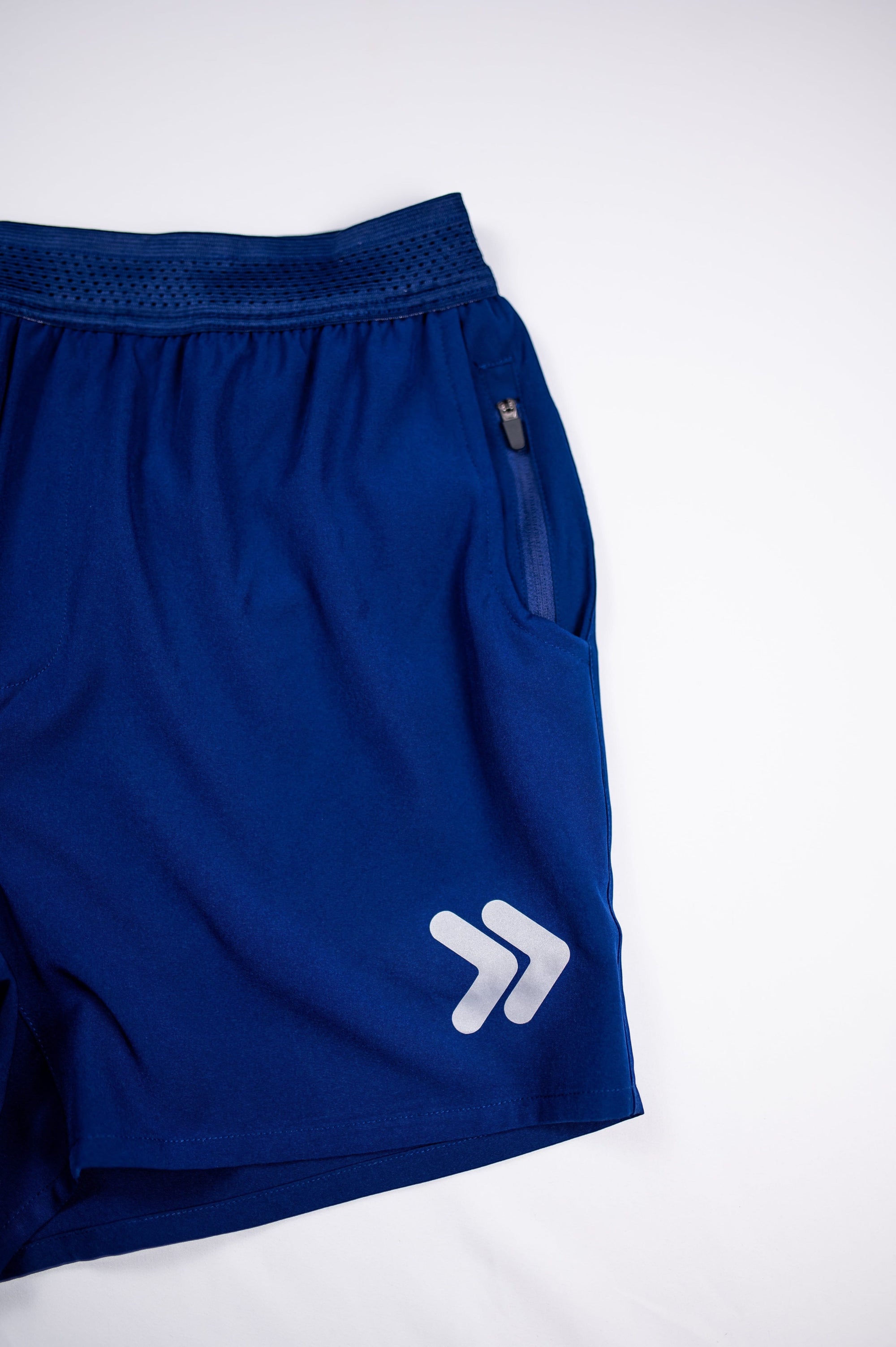 MOVE sport apparel men's blue running shorts with a breathable waistband, zippered pocket, and reflective logo detail.