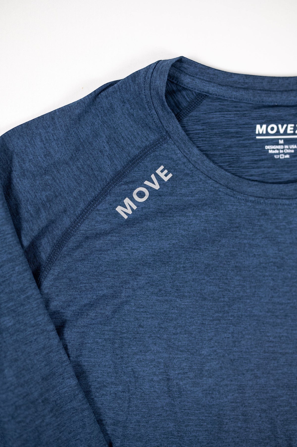 MOVE sport apparel Women's Essential long sleeve shirt in heathered blue with reflective shoulder logo detail.