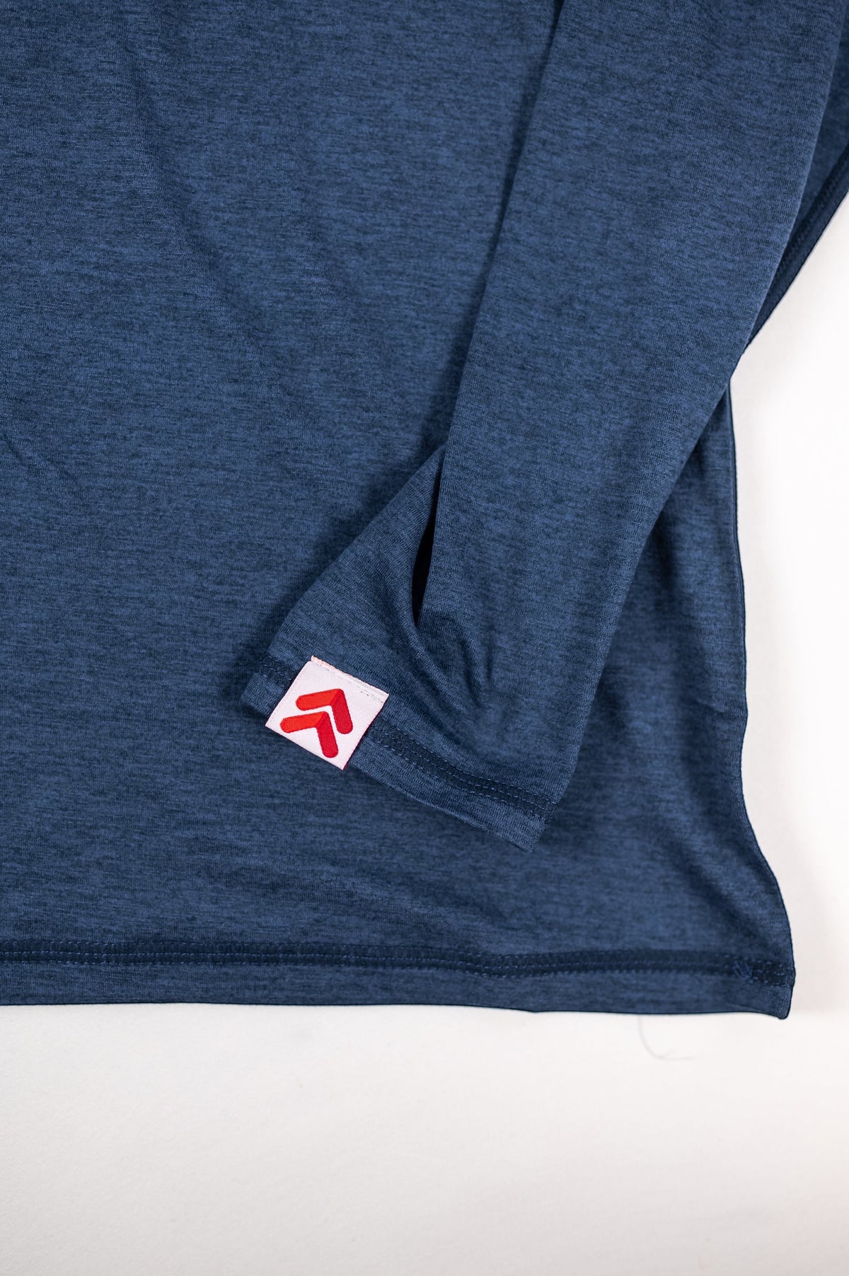 MOVE sport apparel Women's Essential Long Sleeve in heathered blue with thumbhole cuff and red logo patch detail