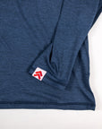 MOVE sport apparel Women's Essential Long Sleeve in heathered blue with thumbhole cuff and red logo patch detail