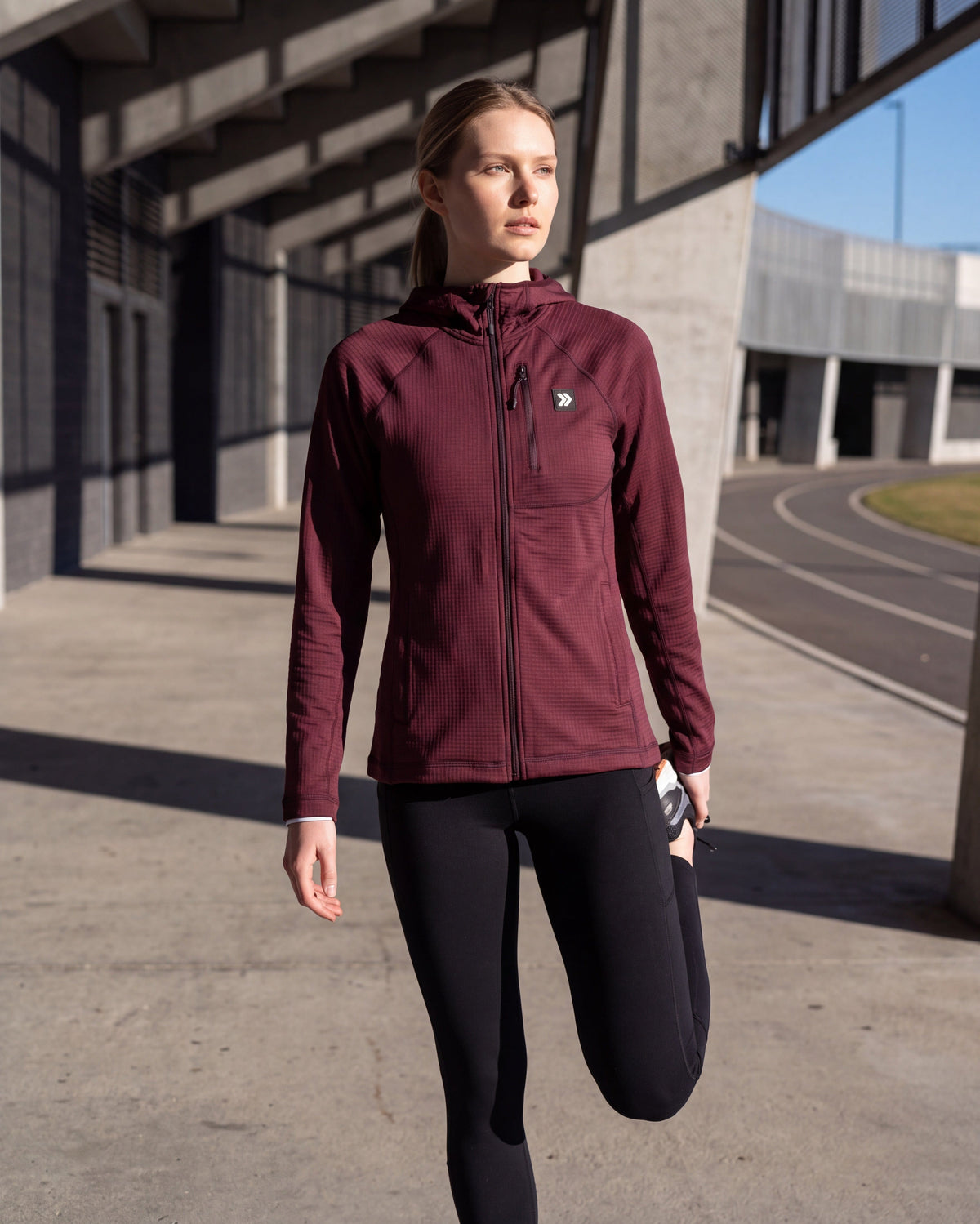 MOVE sport apparel women's burgundy waffle-knit full-zip hoodie with raglan sleeves and chest pocket on a track