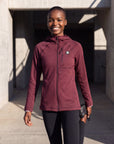 A model wearing a MOVE sport apparel burgundy waffle-knit full-zip hoodie with a chest pocket and raglan sleeves.