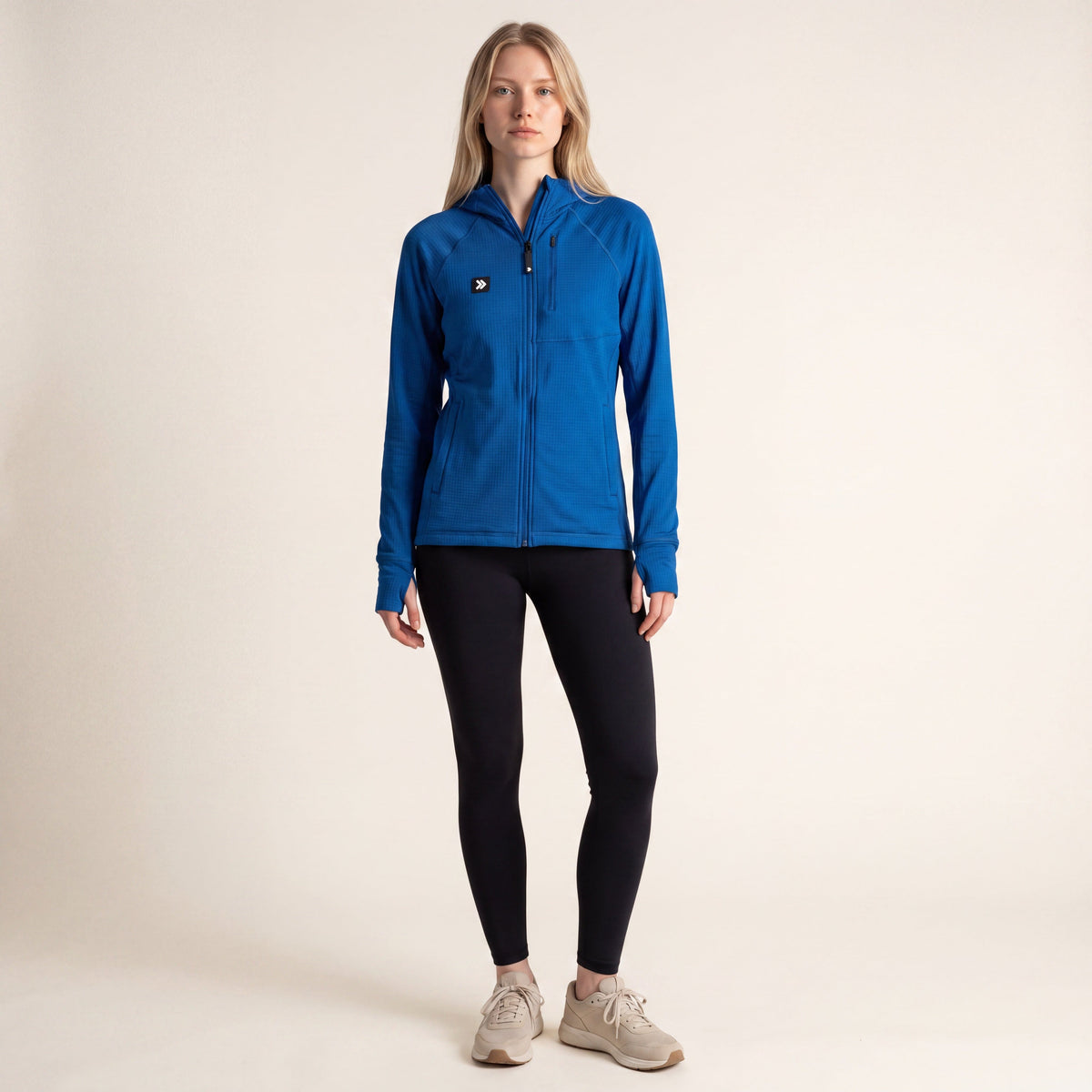A model wearing a MOVE sport apparel blue waffle-knit full-zip hoodie with raglan sleeves and black leggings.
