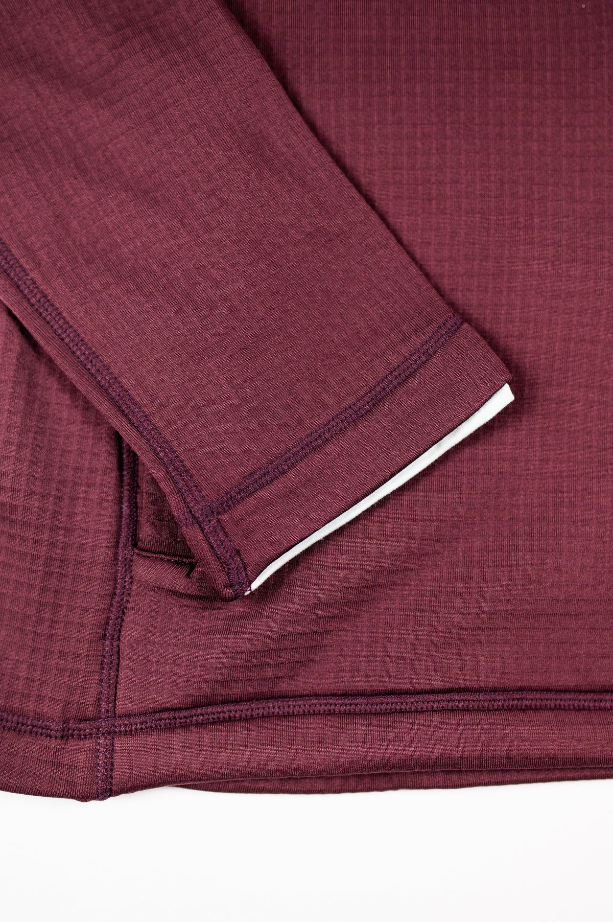 Close-up of MOVE sport apparel women's burgundy waffle-knit hoodie showing textured fabric and sleeve detail.