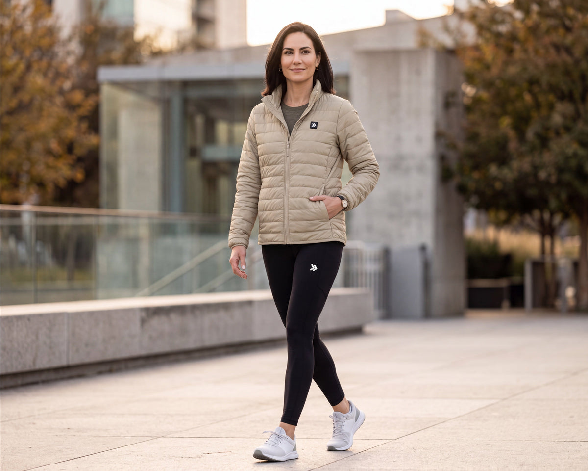 MOVE sport apparel women's lightweight beige quilted down jacket worn by a woman walking outdoors in athletic gear.