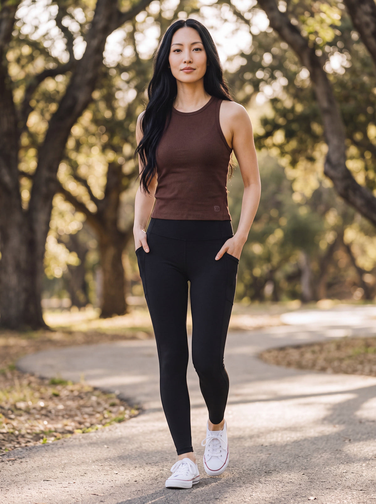 MOVE sport apparel brown ribbed cropped tank top worn by a woman with black leggings on a park path