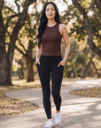 MOVE sport apparel brown ribbed cropped tank top worn by a woman with black leggings on a park path