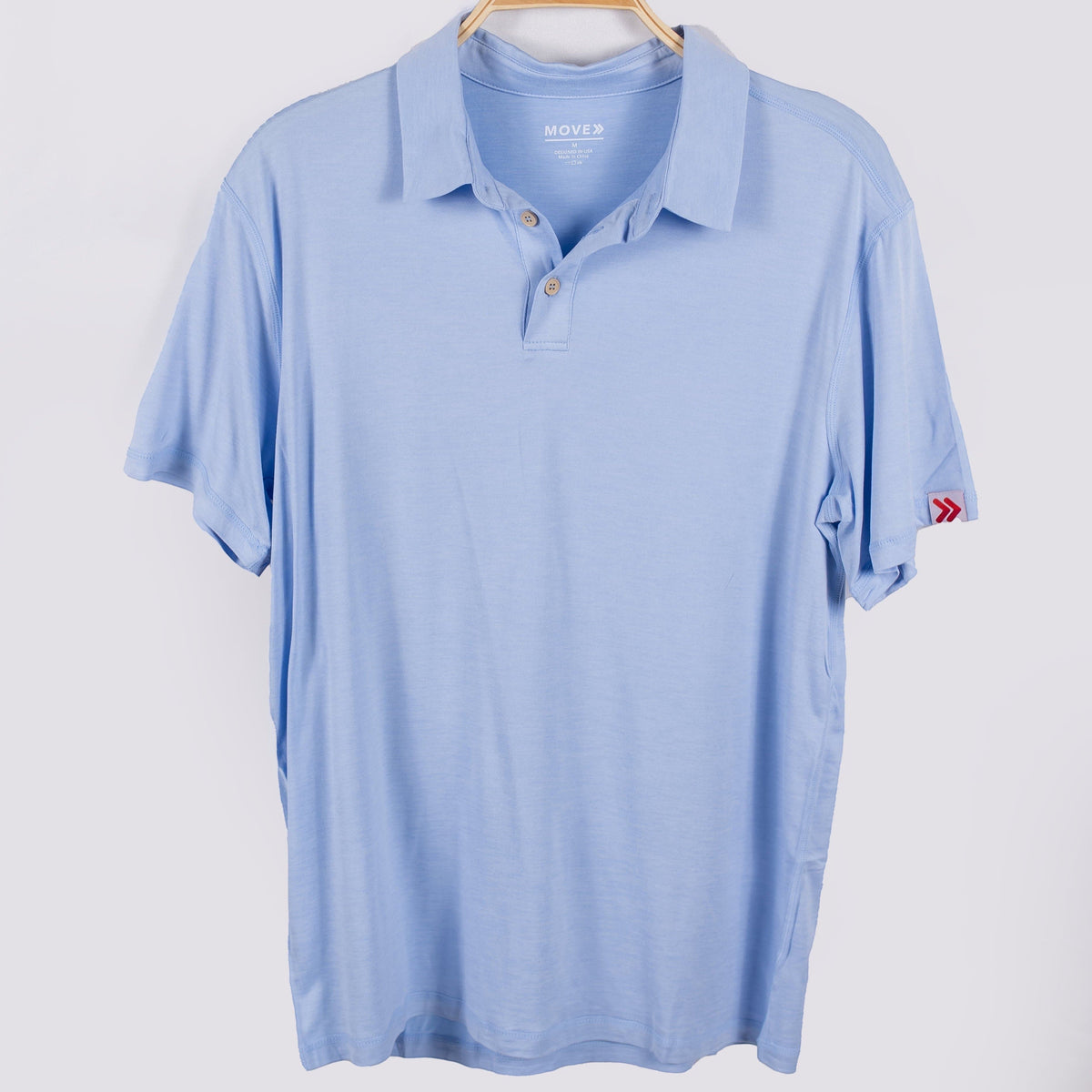 MOVE Sport Apparel Essential Polo Shirt. Windsurfer polo hanging, front view with sleeve label.