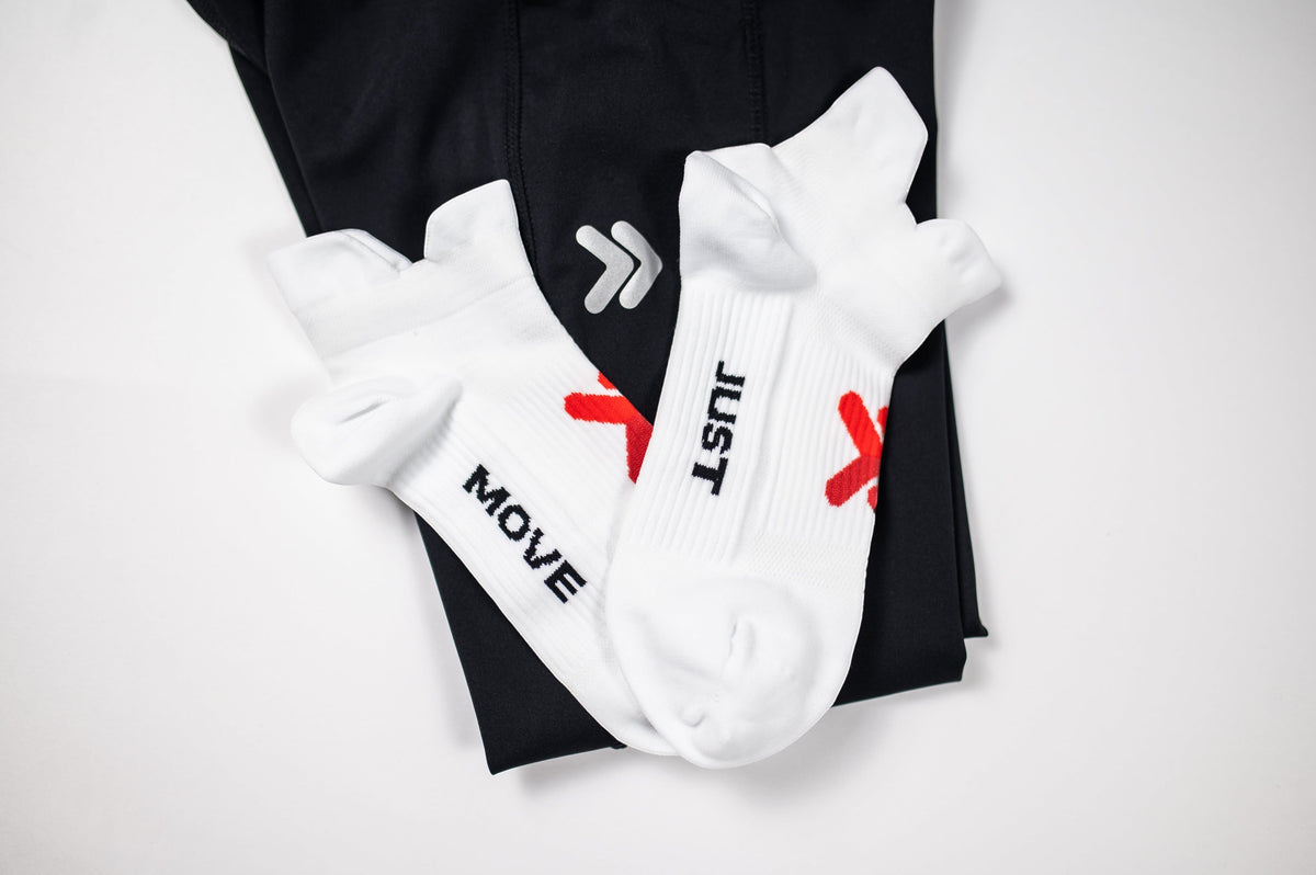 Original white MOVE Sport Apparel Performance Midweight Double Tab Socks with raised front and rear tabs, red chevrons and black JUST MOVE lettering.