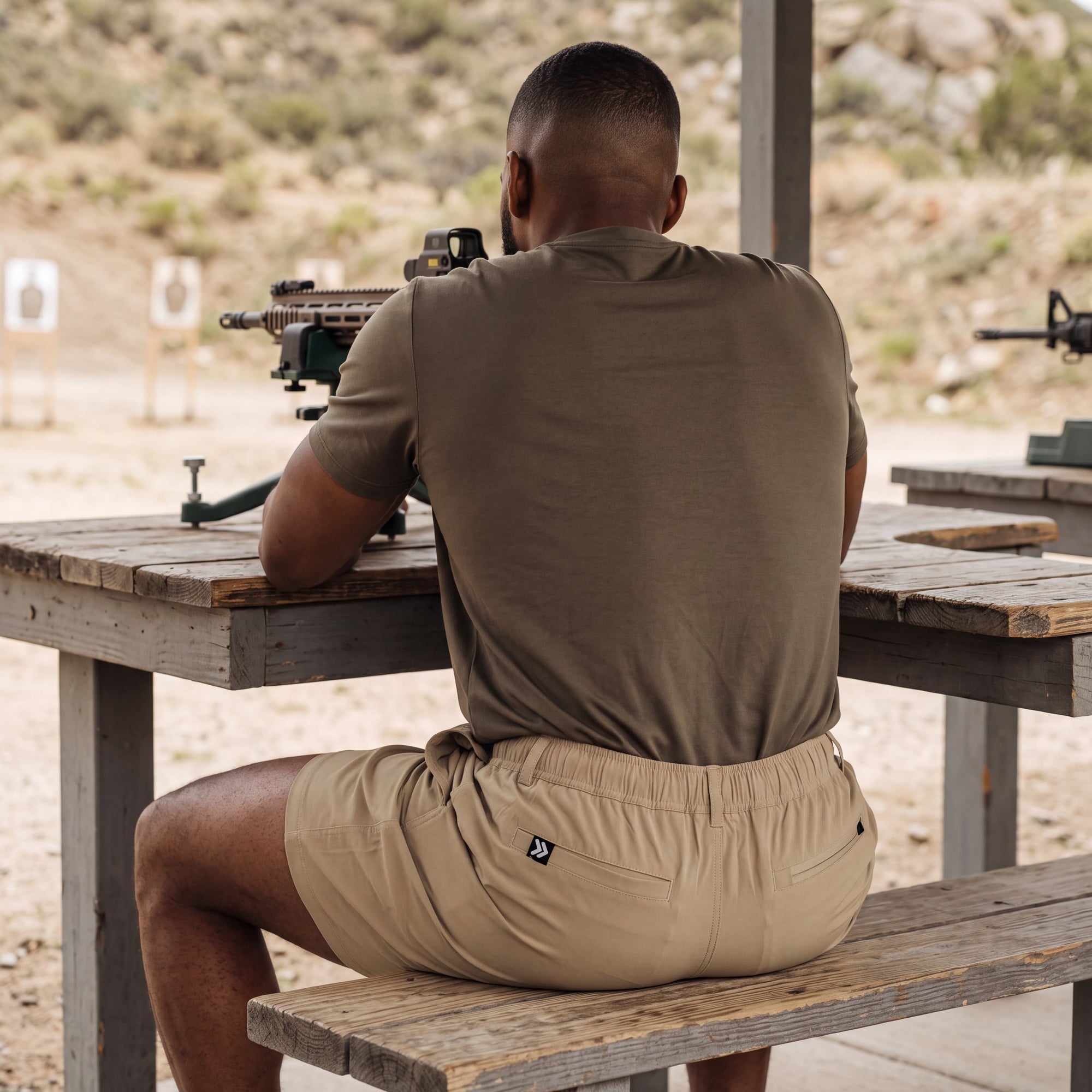 MOVE sport apparel men's tan ripstop shorts with 7.5 inch inseam worn by a man at an outdoor shooting range