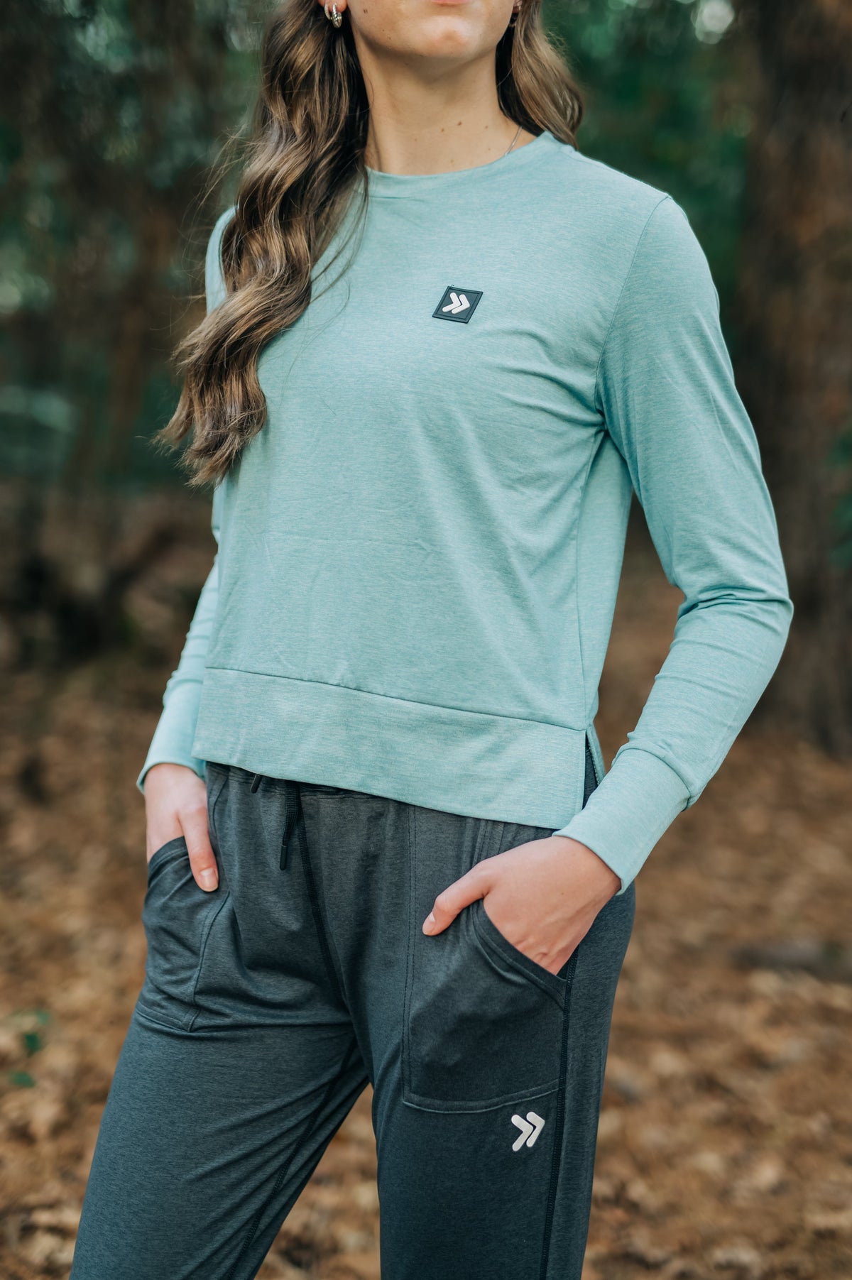 MOVE sport apparel long sleeve crewneck sweatshirt in heathered teal with side-slit hem and signature logo patch