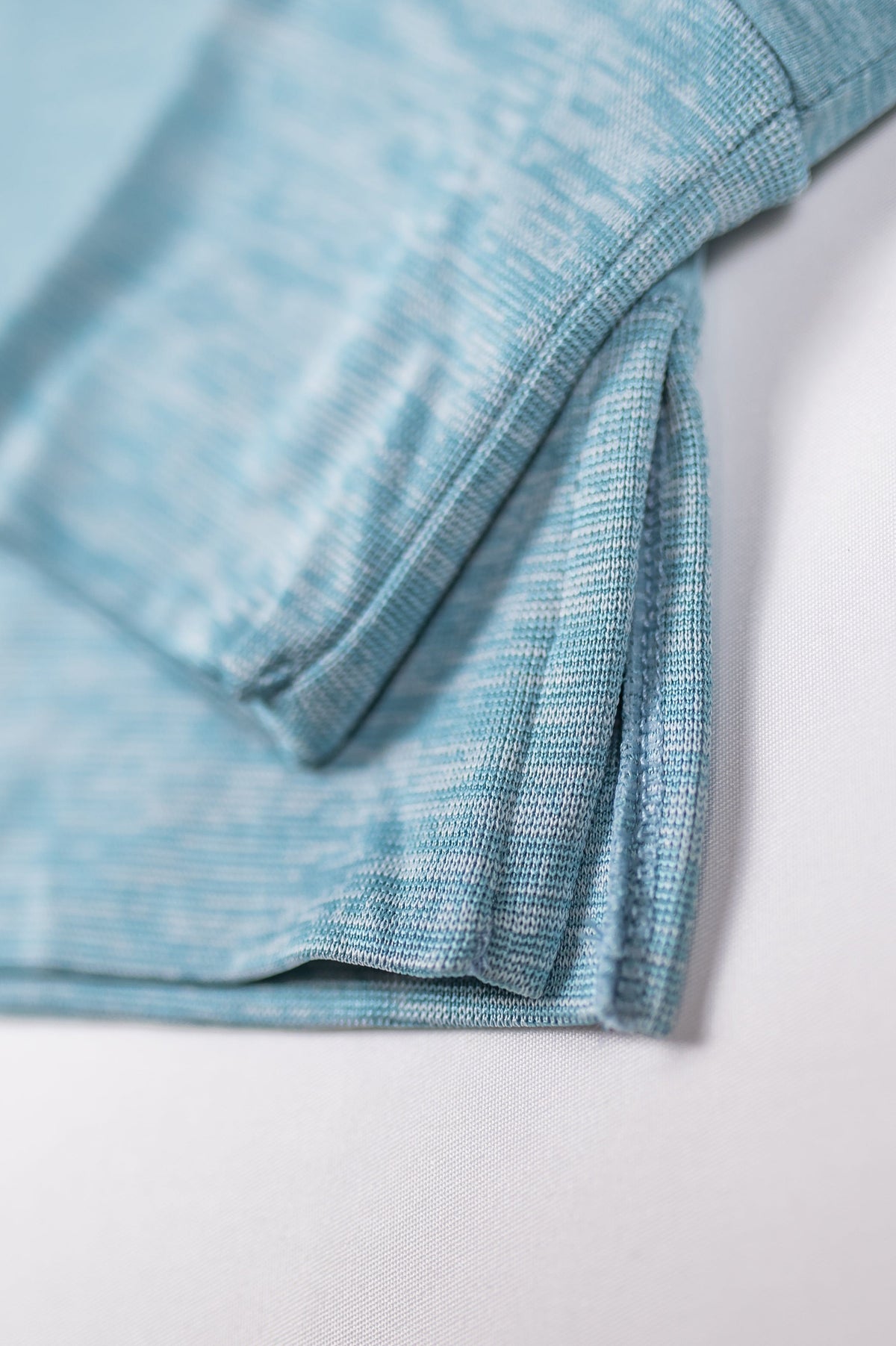 MOVE sport apparel blue heathered long sleeve sweatshirt featuring a ribbed cuff and a modern side-slit hem detail.