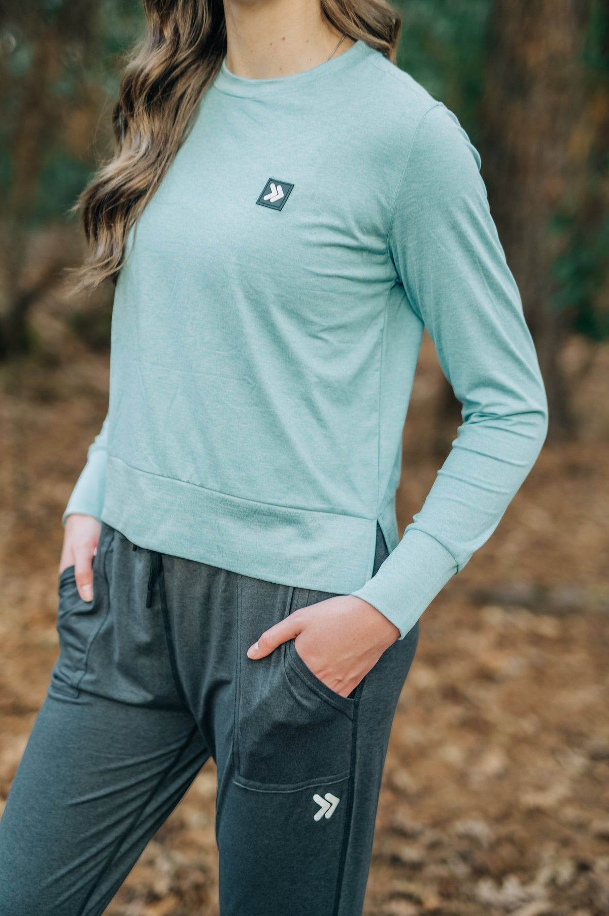 MOVE sport apparel long sleeve crewneck sweatshirt in light teal with side slits and signature logo patch