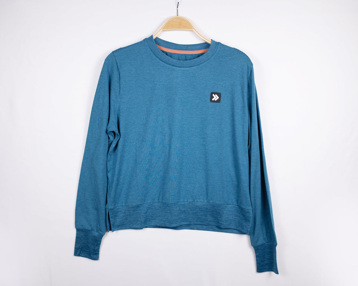MOVE sport apparel blue heathered long sleeve crewneck sweatshirt with ribbed cuffs and side-slit hem on a hanger.