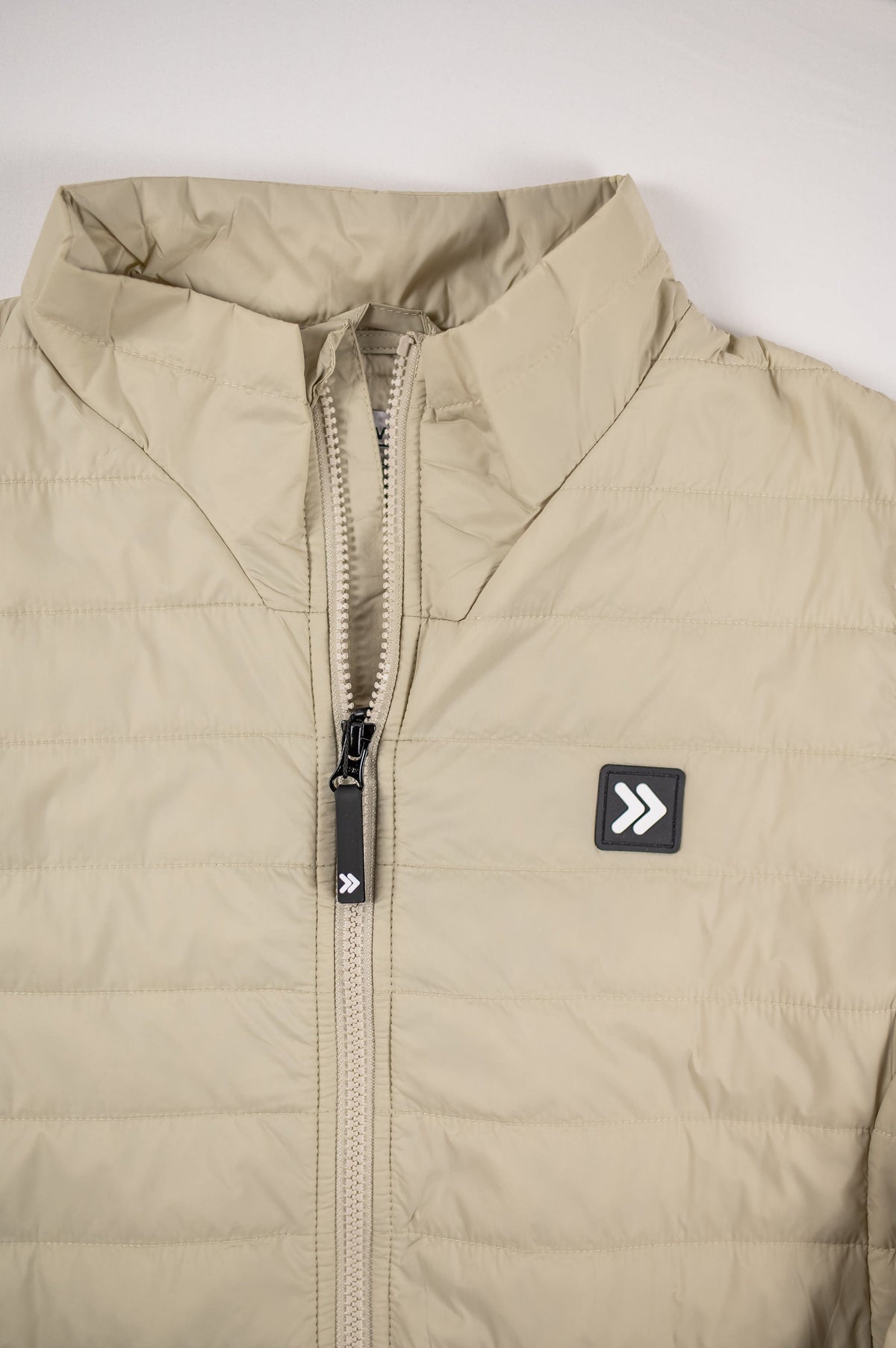 Close-up of the stand collar, quilting and chest patch on the women’s Silver Birch Lightweight Down Jacket.