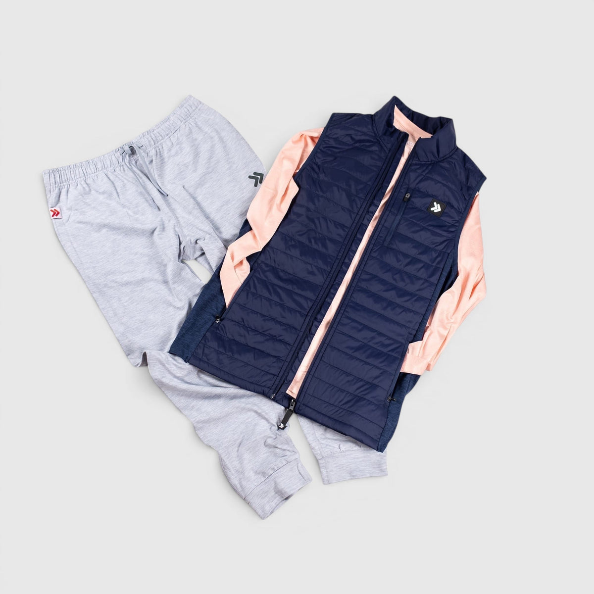Silver Cloud MOVE Sport Apparel Women’s Essential Jogger Black Label styled in a flat lay with a vest and long sleeve top.