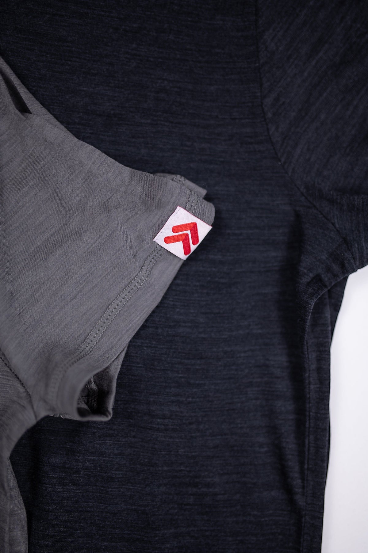 MOVE Sport Apparel women’s Merino Short Sleeve T-Shirt: Black and Granite Gray Merino shirts shown with original red-and-white sleeve tabs.
