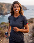 MOVE Sport Apparel women’s Merino Short Sleeve T-Shirt: Woman wearing Black Merino Short Sleeve T-Shirt while running on a coastal trail.