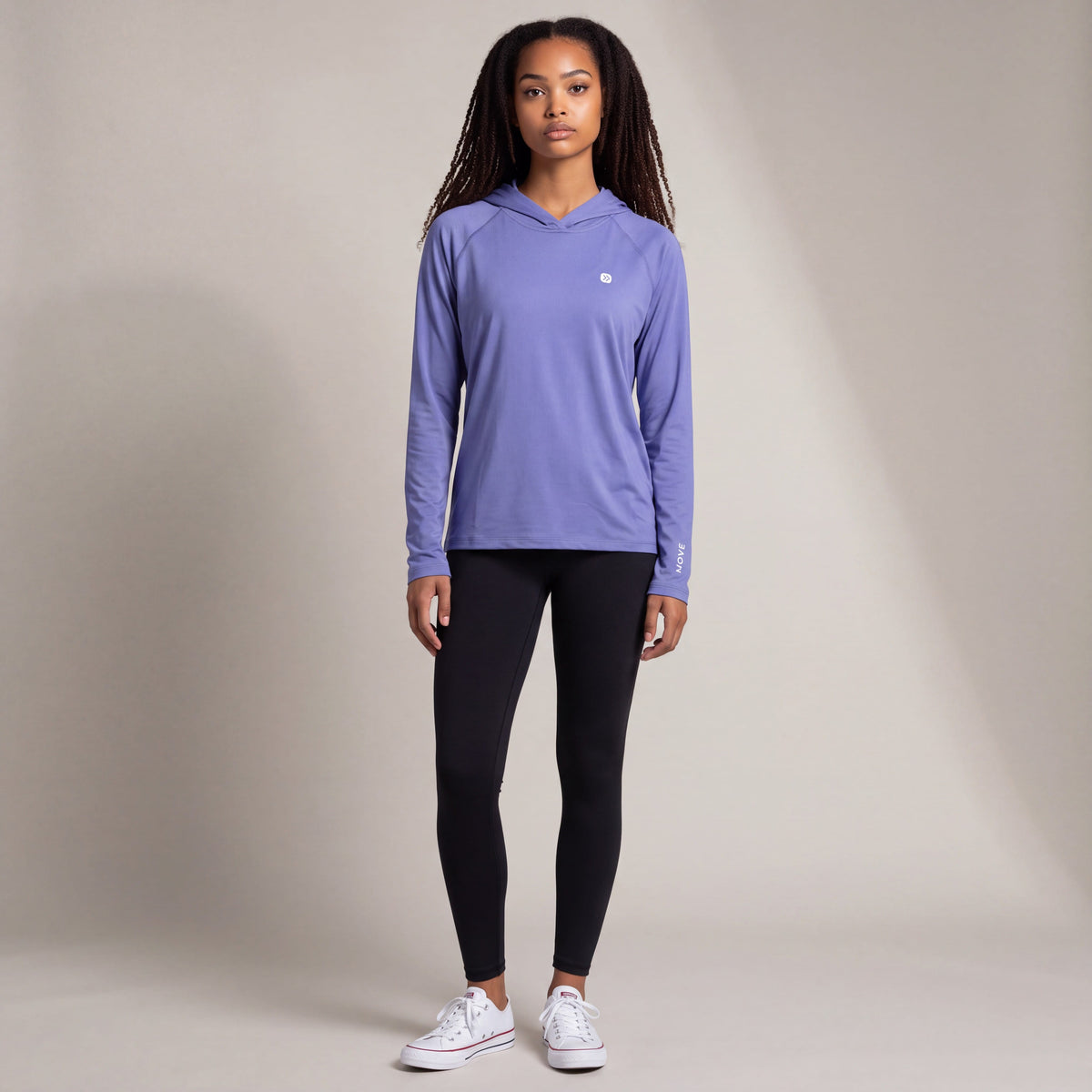 Woman modeling the MOVE Sport Apparel Women’s Lightweight Performance Hoodie in Deep Periwinkle in a neutral studio, showing the original small chest embellishment and sleeve lettering.