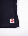 Close view of the original red double-chevron hem tab on the Black MOVE Sport Apparel Pure Stretch Full Length Tank Top.