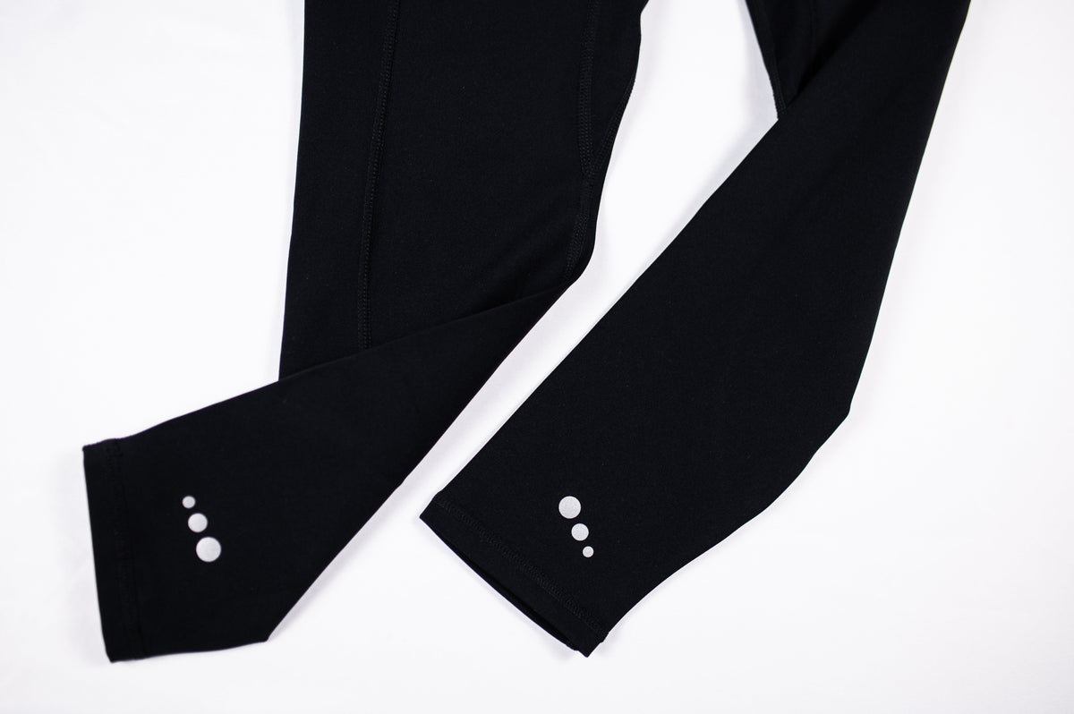 Close-up of the original three white ankle dots on black MOVE Sport Apparel women’s Brushed Running Leggings.