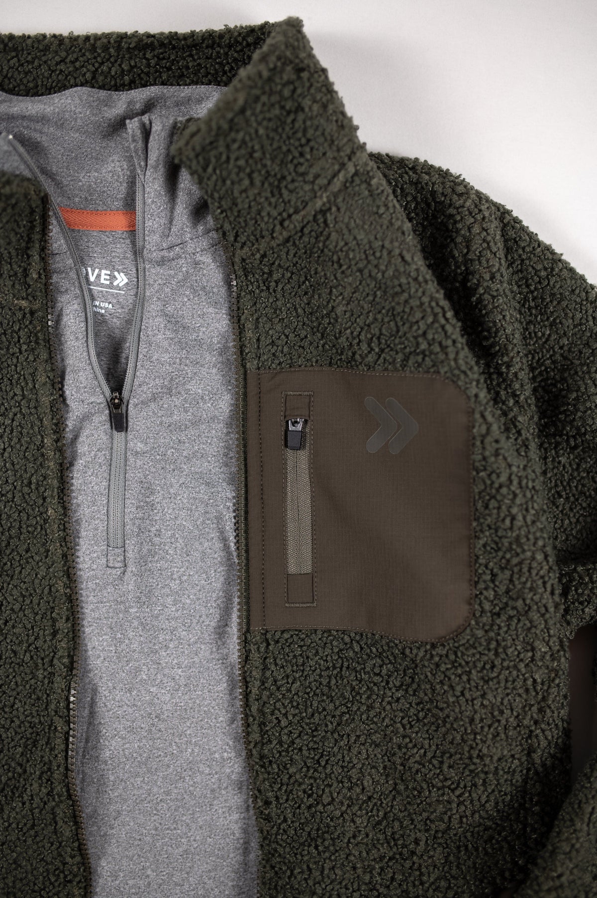 MOVE sport apparel women's olive green sherpa jacket with grey zip-up lining and a dark brown chest pocket.