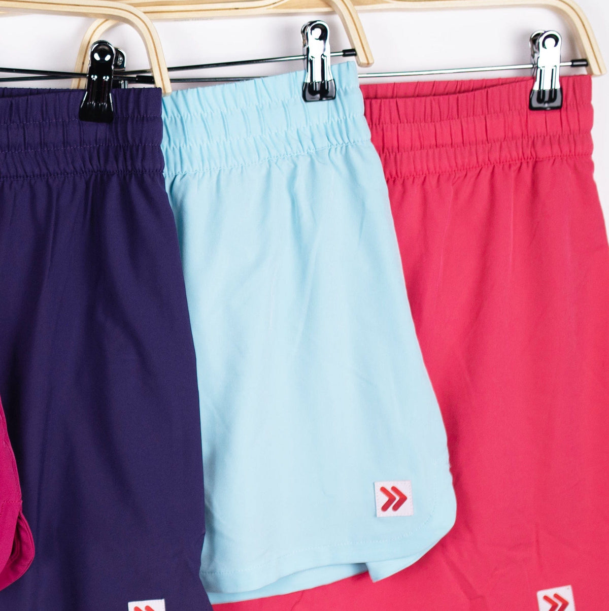 Purple, Atomizer pale blue and pink MOVE Sport Apparel women’s Skorts hanging together with original hem tabs.