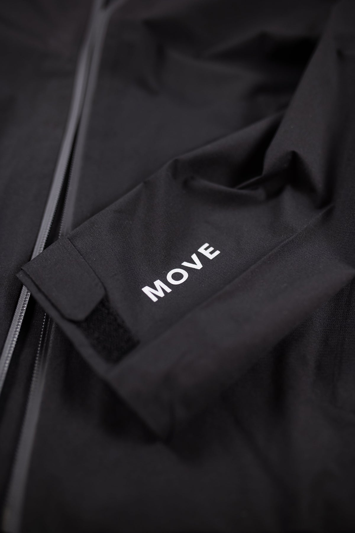 Black MOVE Sport Apparel women’s waterproof jacket cuff detail showing the MOVE lettering.