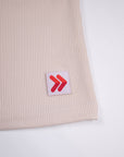 Close view of ribbed fabric and the red-and-white hem tab on the Crystal Gray MOVE Sport Apparel Women’s FlexRib Full Length Tank.
