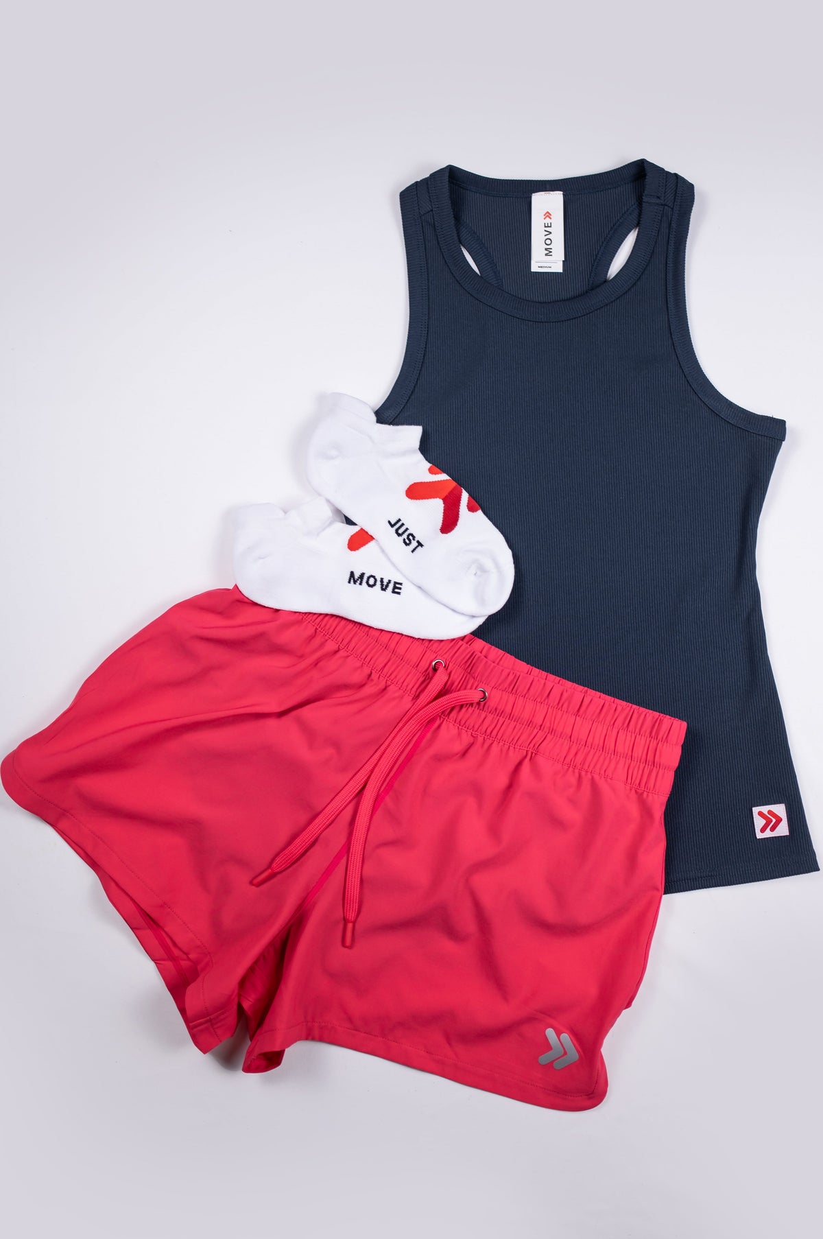 India Ink MOVE Sport Apparel Women’s FlexRib Full Length Tank arranged with red running shorts and a white cap.