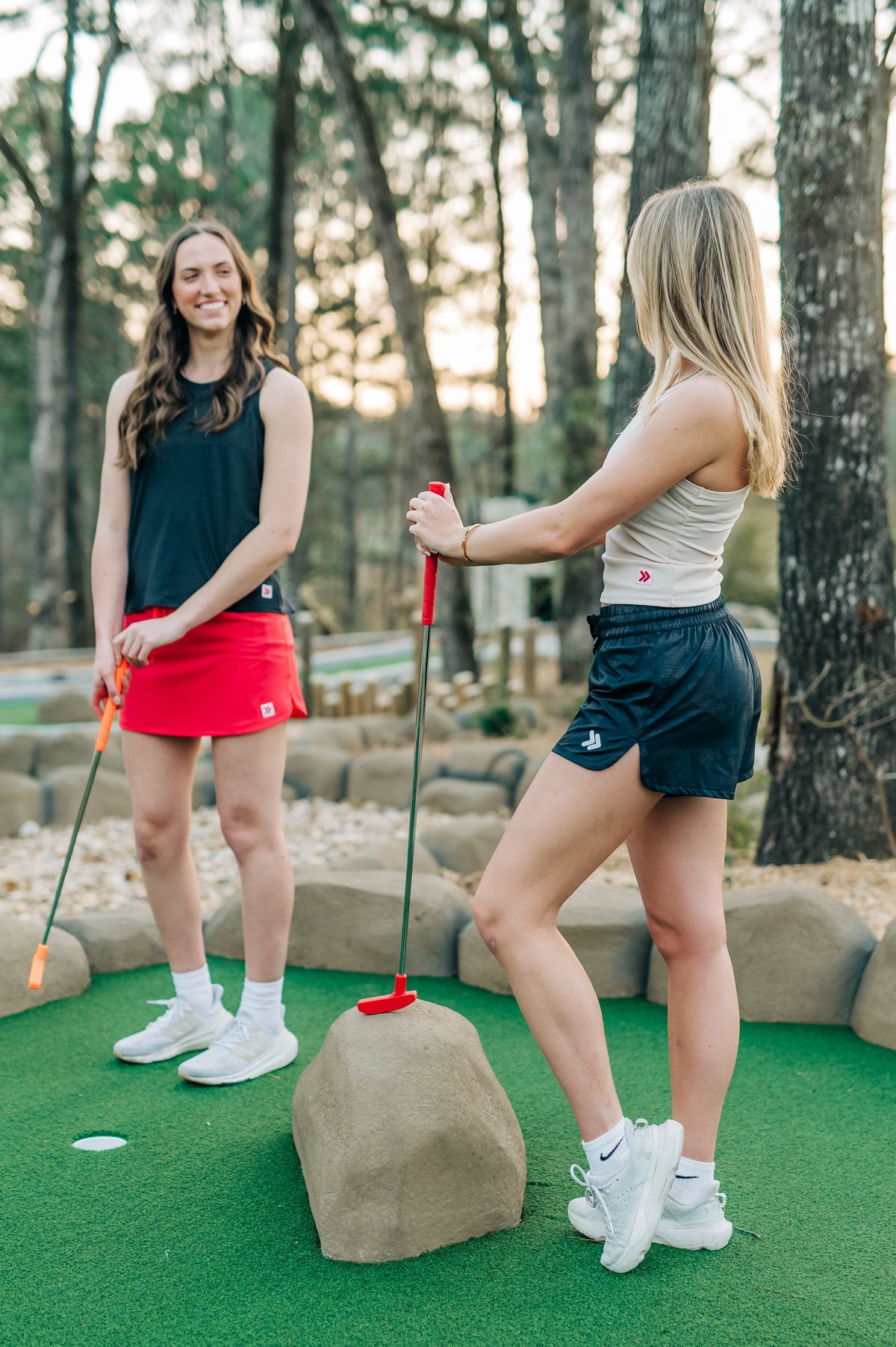 Two women wearing India Ink and Crystal Gray MOVE Sport Apparel Women’s FlexRib Full Length Tanks at a mini-golf course.