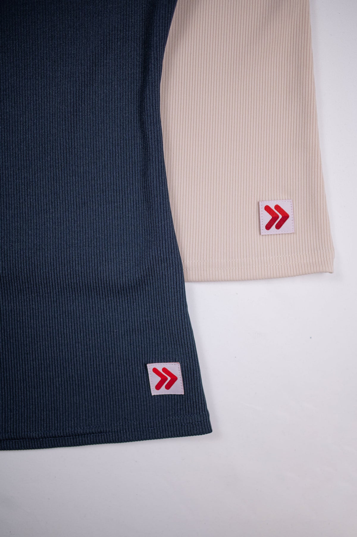 Ribbed fabric and hem tabs on India Ink and Crystal Gray MOVE Sport Apparel Women’s FlexRib Full Length Tanks.