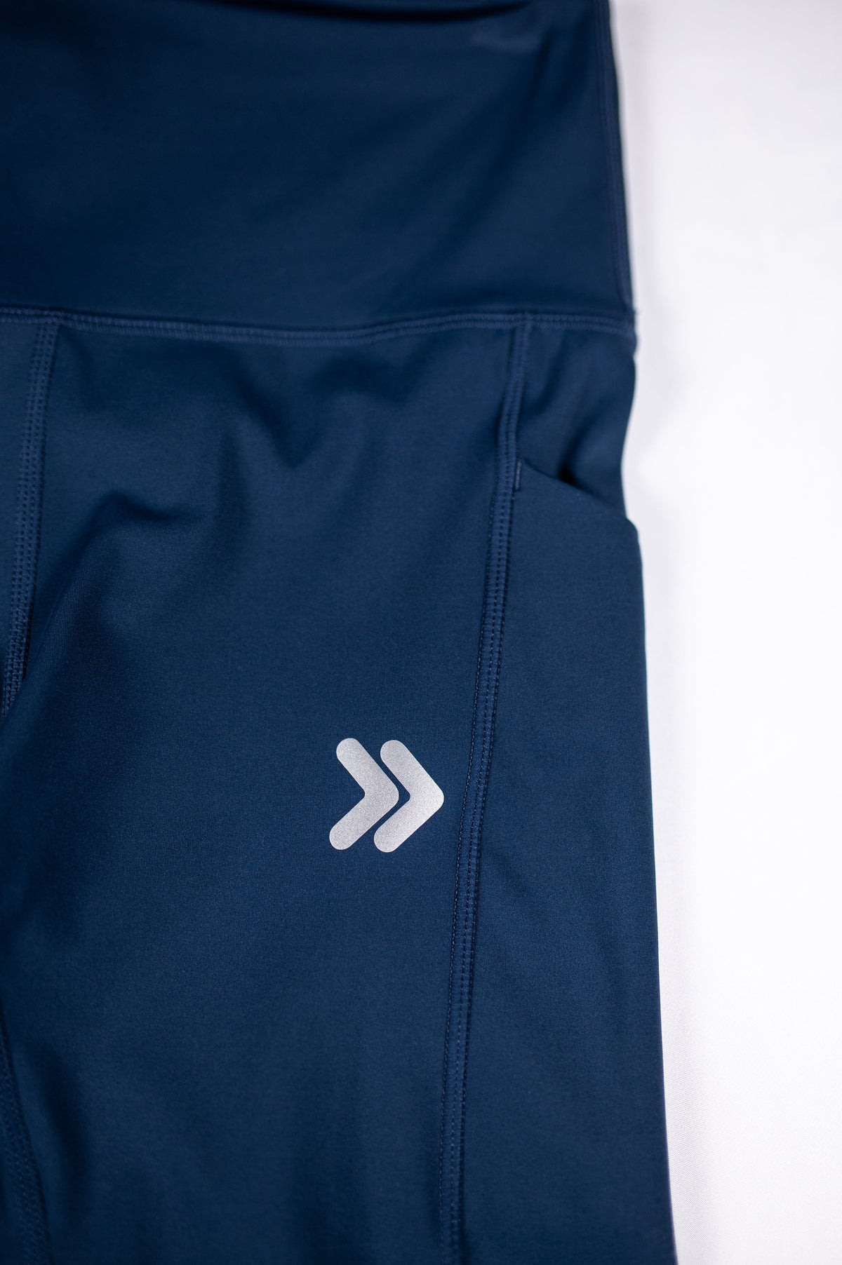 MOVE Sport Apparel women’s 25-Inch Running Tights: Close view of the side pocket and original thigh chevrons on Pageant blue tights.