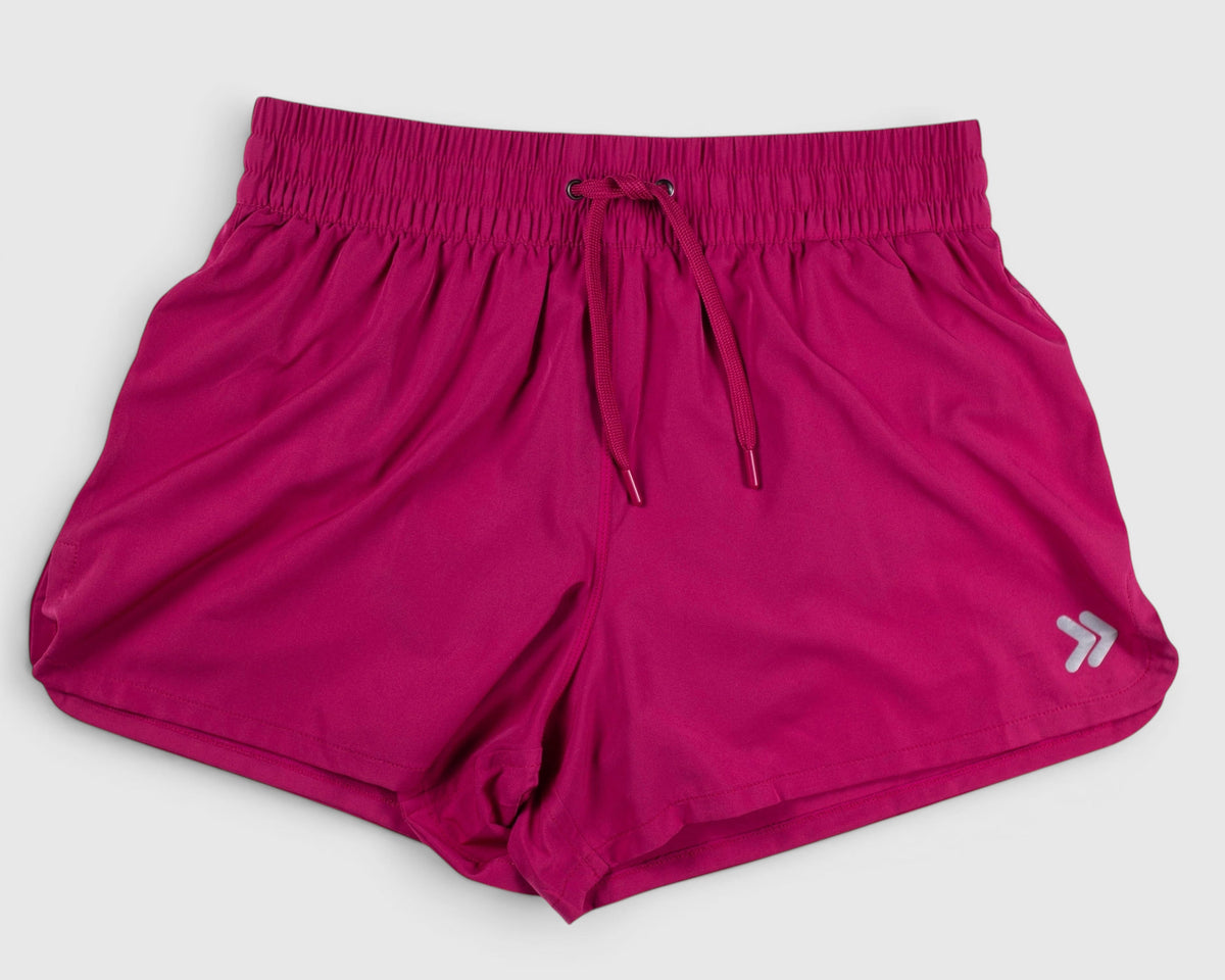 Pink MOVE Sport Apparel women’s running shorts shown flat with elastic waistband and original hem embellishment.