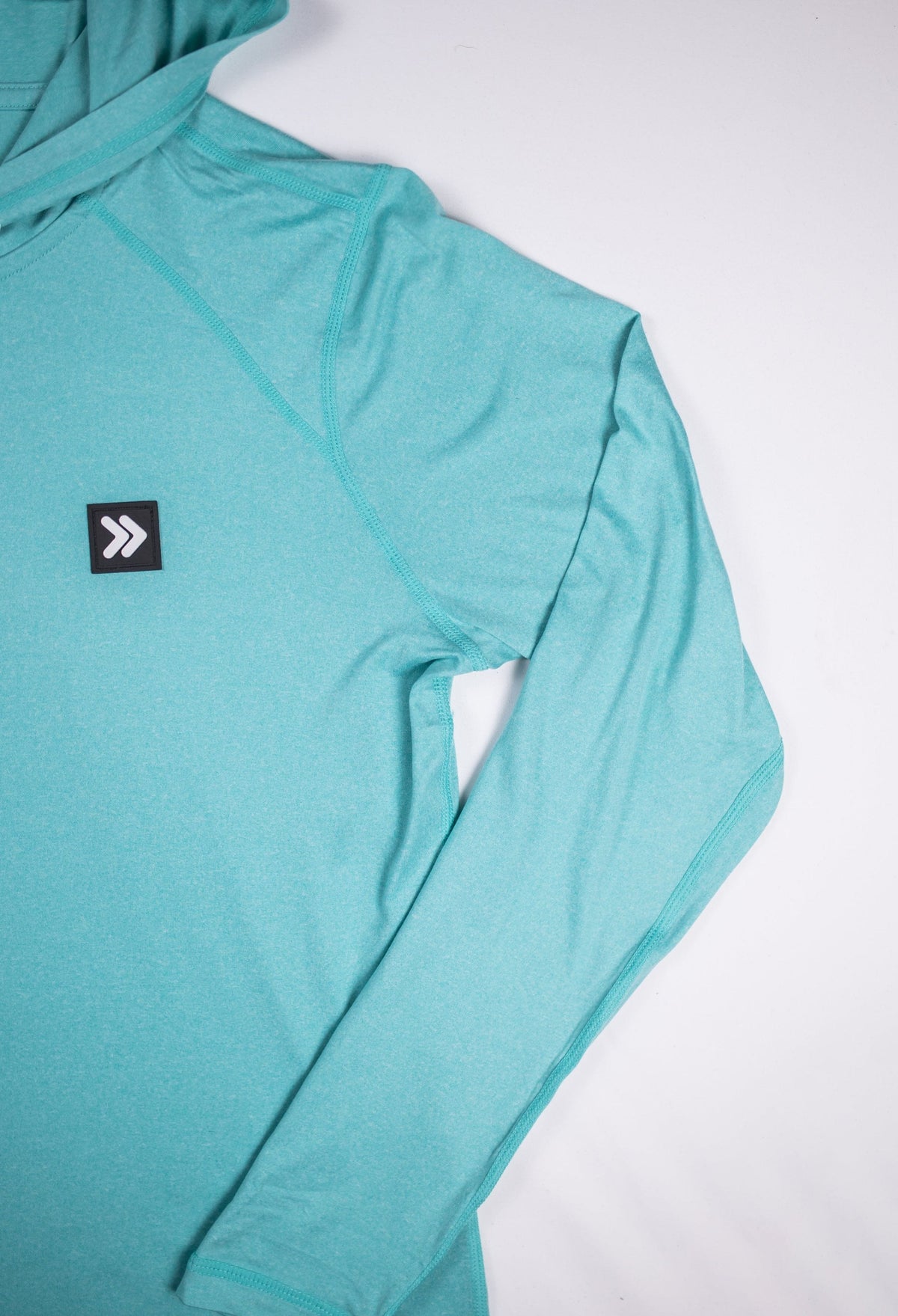 MOVE Sport Apparel women’s Black Label Lightweight Sun Hoodie: Close view of the original chest patch and sleeve on the Aqua Splash sun hoodie.