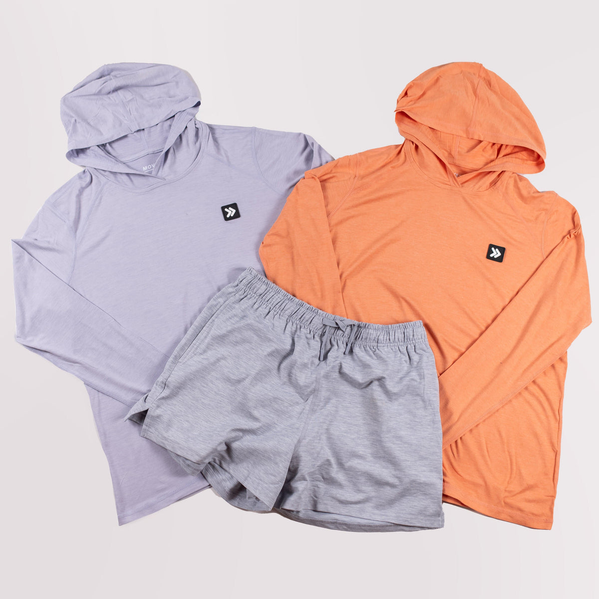 MOVE Sport Apparel women’s Black Label Lightweight Sun Hoodie: Icelandic Blue and Coral Reef sun hoodies arranged with grey shorts.