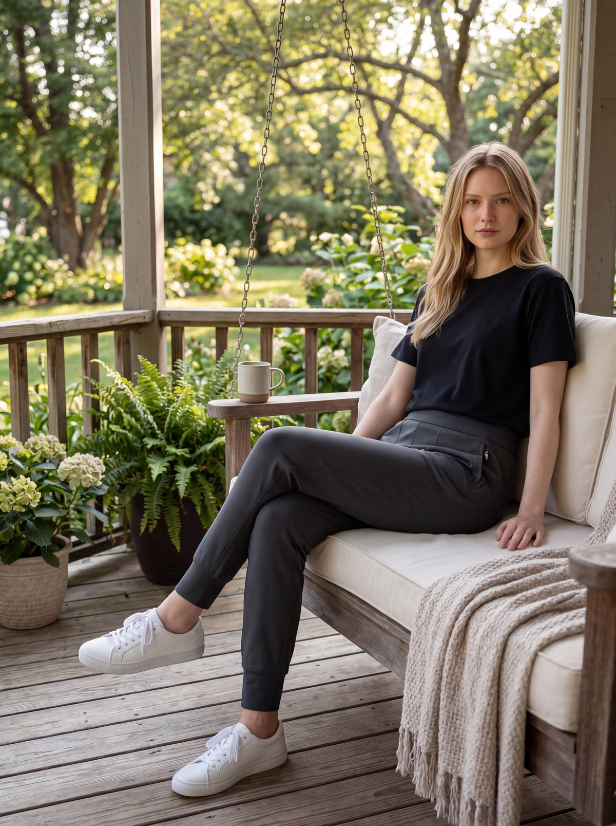 Woman seated on a porch wearing MOVE Sport Apparel Women’s Cloud Joggers in Soft Black.