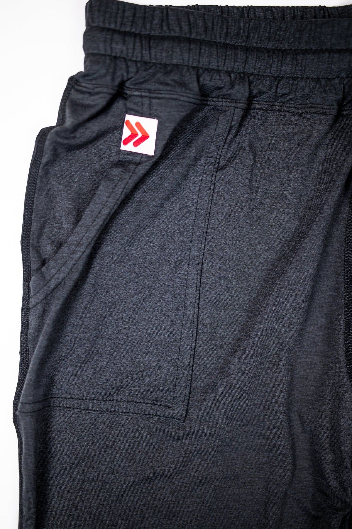 Black Essential Joggers pocket opening with the original white tab and red double chevrons.